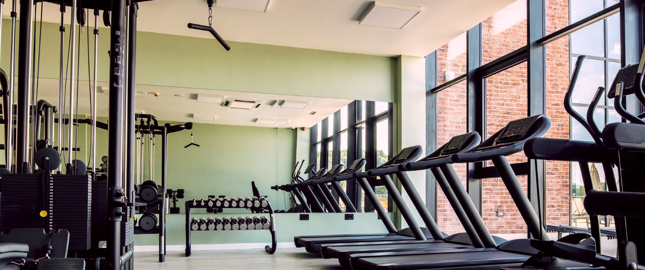 На фото изображен спортивный зал с множеством тренажеров